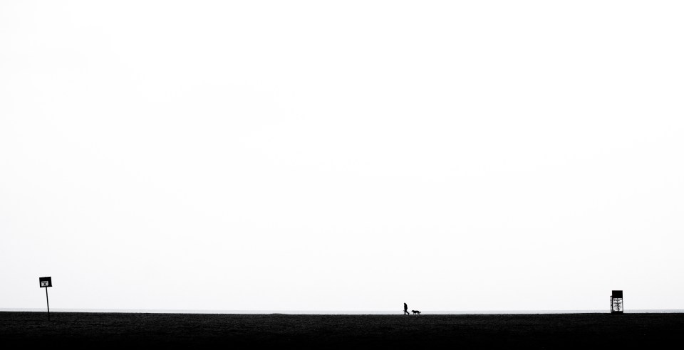 A man walks his dog at Woodbine beach in Toronto, Ontario on December 7th, 2015